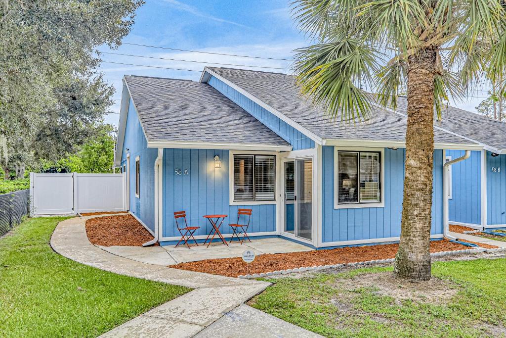 una casa blu con due sedie e una palma di Bradmore Casita a Palm Coast