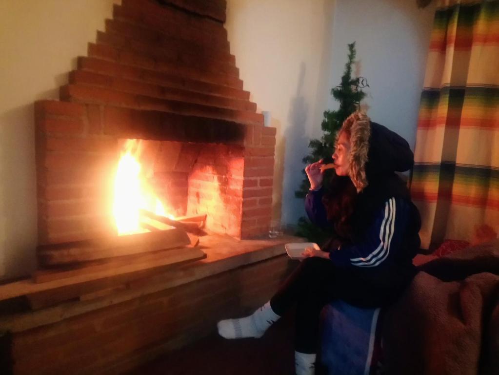 El Pacífico的住宿－Cabaña con Bañera en Puesta de Sol，坐在壁炉前的女人