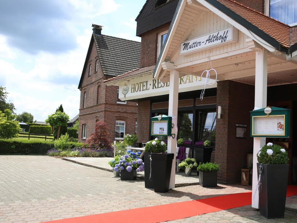 a store with potted plants in front of a building at Landhotel Mutter Althoff in Olfen