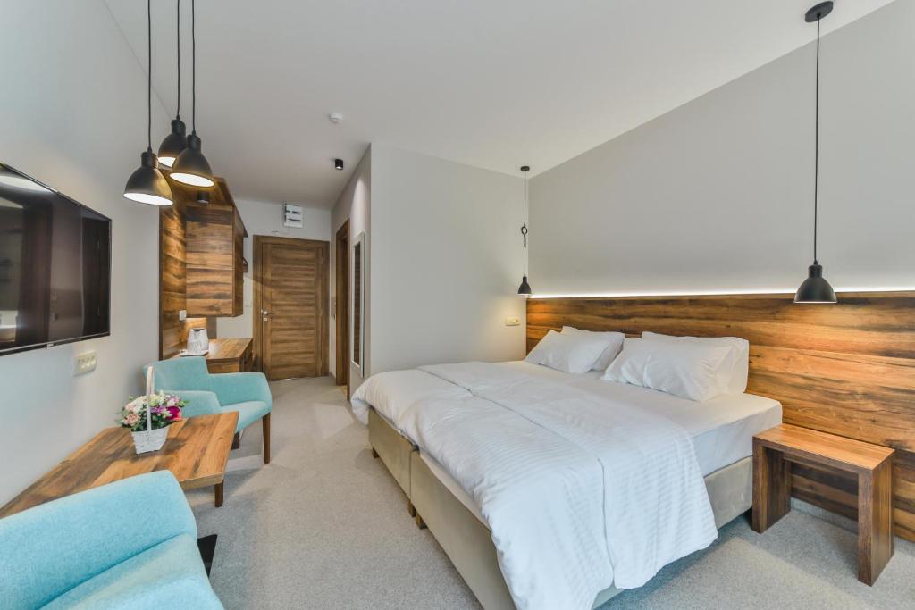 Hotel Vladimir في بودفا: غرفة نوم بسرير كبير وكرسي ازرق