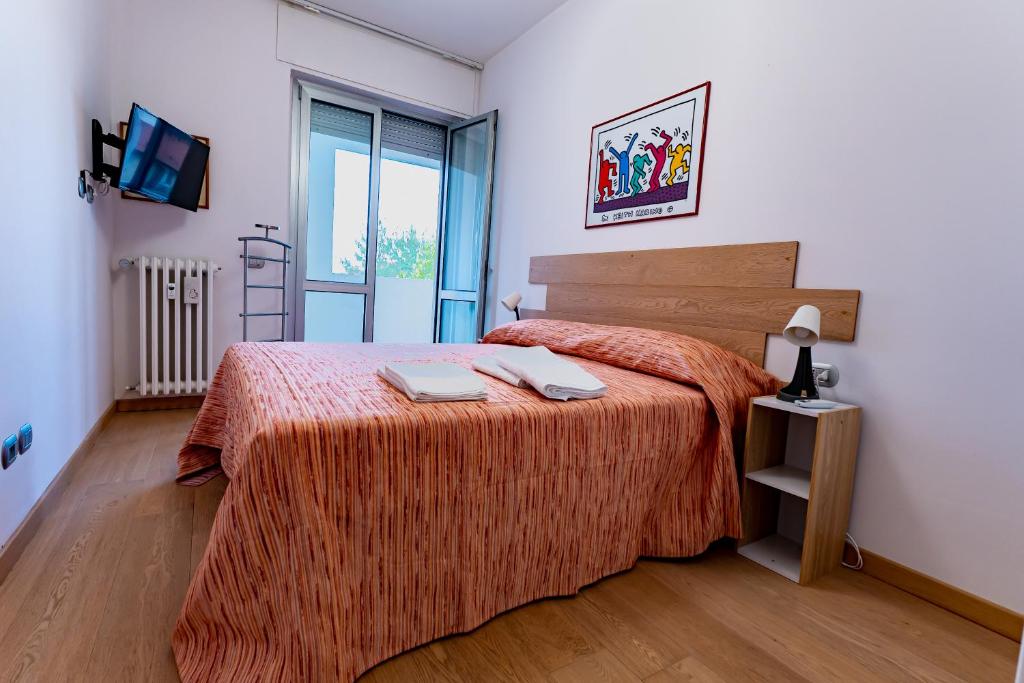 a bedroom with a large bed with a orange blanket at Farini Apartment in Milan