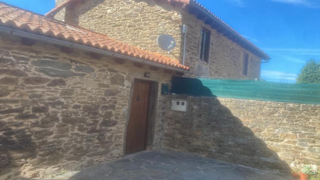 a stone house with a door and a stone wall at Casal de Pedra in Santa Irene