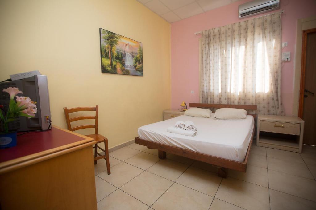 特拉維夫的住宿－天空旅館，一间卧室配有一张床、一张书桌和一台电视。