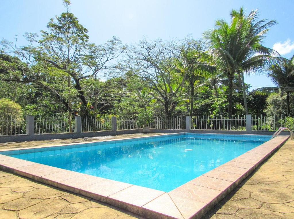 una piscina con una valla y árboles en Casa de campo c piscina e churrasq em Saquarema RJ, en Jaconé