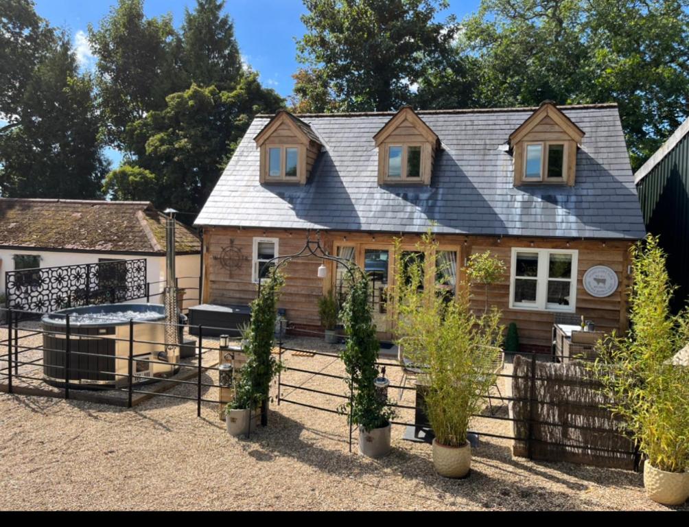 a house with a fence and potted plants in front of it at Winterberry Barn in Romsey