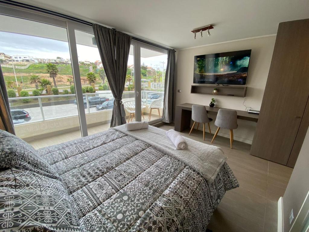 1 dormitorio con cama y ventana grande en Tranquilo departamento Dunas de Concon, en Concón