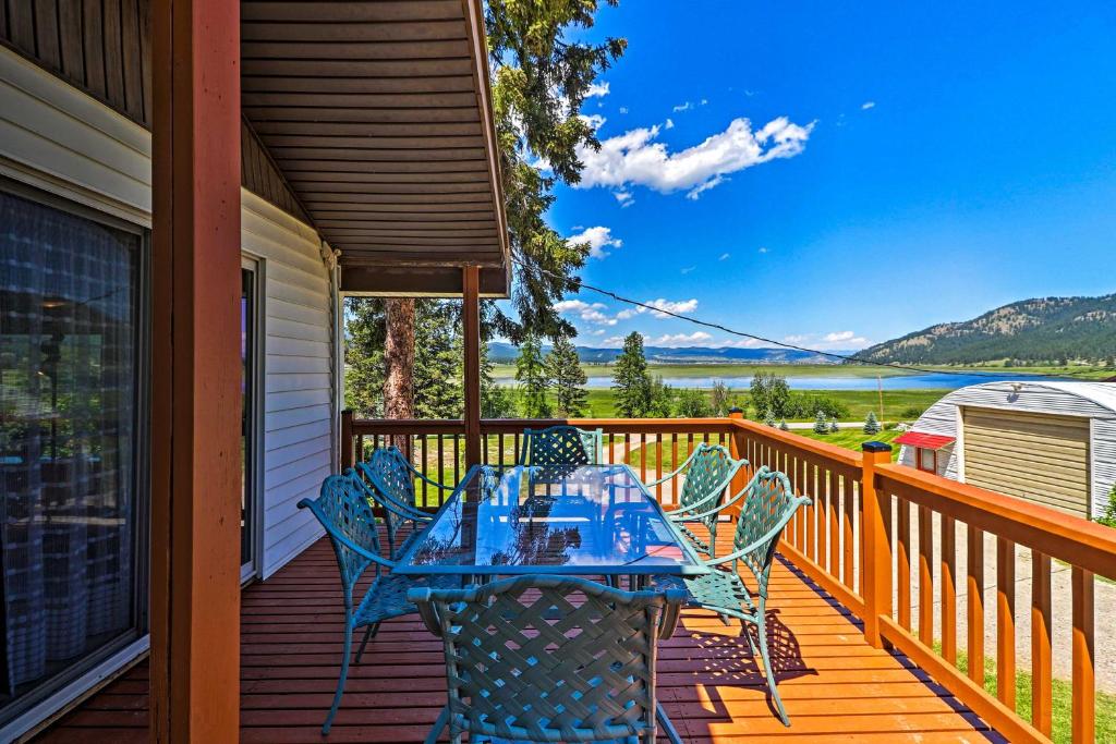 a dining table on a deck with a view of a lake at Cozy Montana Lake View Getaway - Fish and Hike! in Kalispell