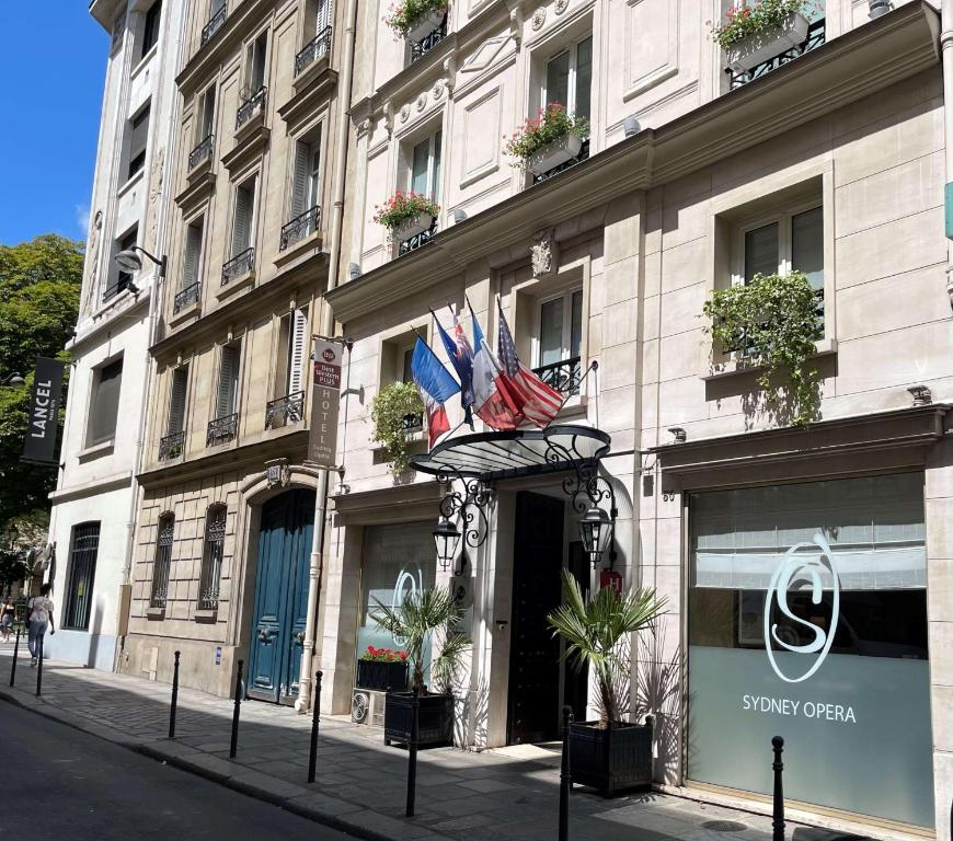 un edificio con banderas en él en una calle de la ciudad en Best Western Plus Hotel Sydney Opera en París