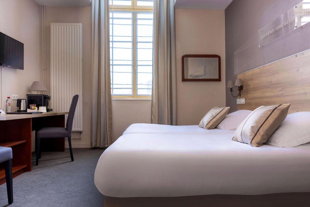 Habitación de hotel con cama grande y escritorio. en Best Western Hôtel Hermitage en Montreuil-sur-Mer