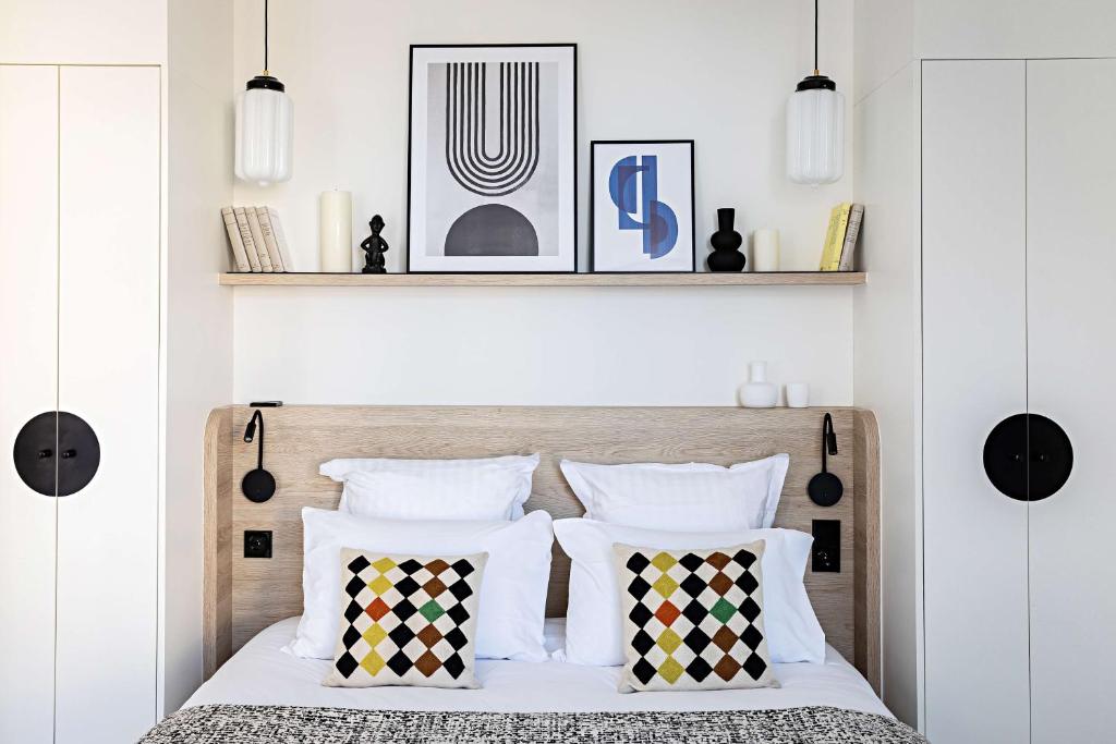 a bedroom with a bed with black and white pillows at Le Riviera Collection, Signature Collection by Best Western in Nice