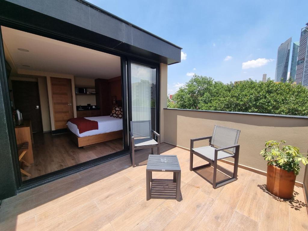 Un balcón con una cama y una silla en un edificio. en Condesa Cibel, en Ciudad de México