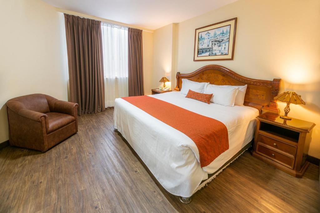 una habitación de hotel con una cama grande y una silla en Miraflores Colon Hotel, en Lima
