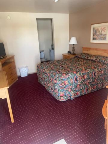 a hotel room with a bed and a desk at Artesia Inn- No Service Fees in Artesia