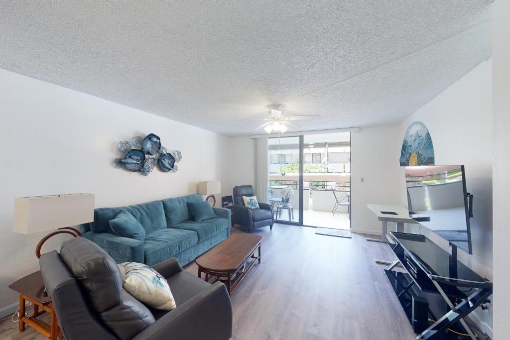 a living room with a couch and a tv at White Sands Resort #108 in Kailua-Kona