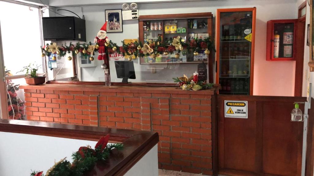 a bar with a santa claus behind the counter at Hotel cambulos in Manizales