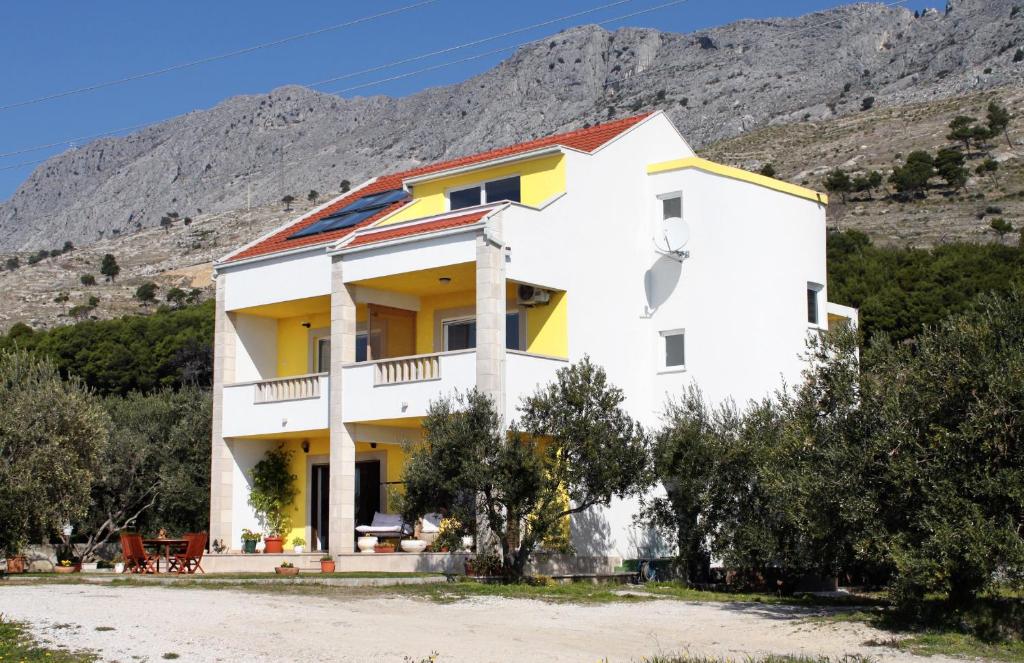 a white house with a mountain in the background at Apartment Duce 2778b in Duće