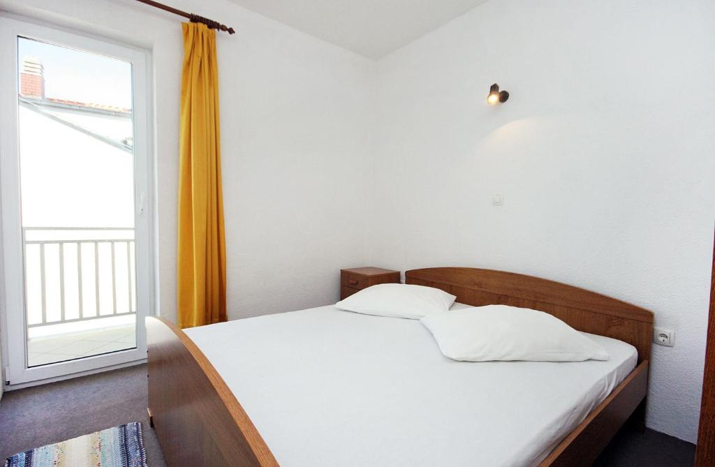 a bed in a room with a large window at Apartments with a parking space Duce, Omis - 3190 in Duće