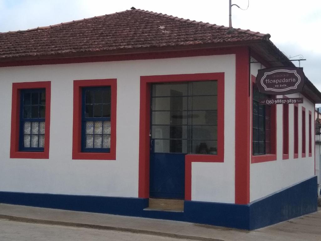 a red white and blue building with a door at Hospedaria Vó Zazá in Carrancas