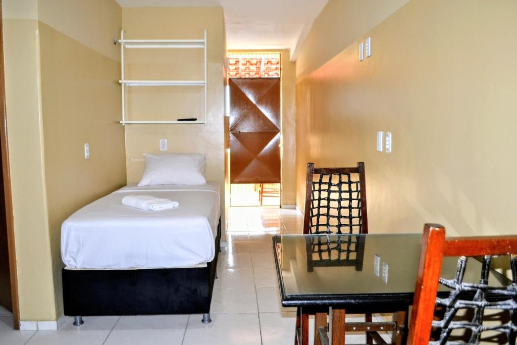 um pequeno quarto com uma cama e uma mesa em Iracema Praia Flats em Fortaleza