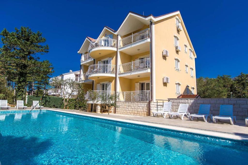 a villa with a swimming pool in front of a building at Apartments with swimming pool Jadranovo, Crikvenica - 3238 in Jadranovo
