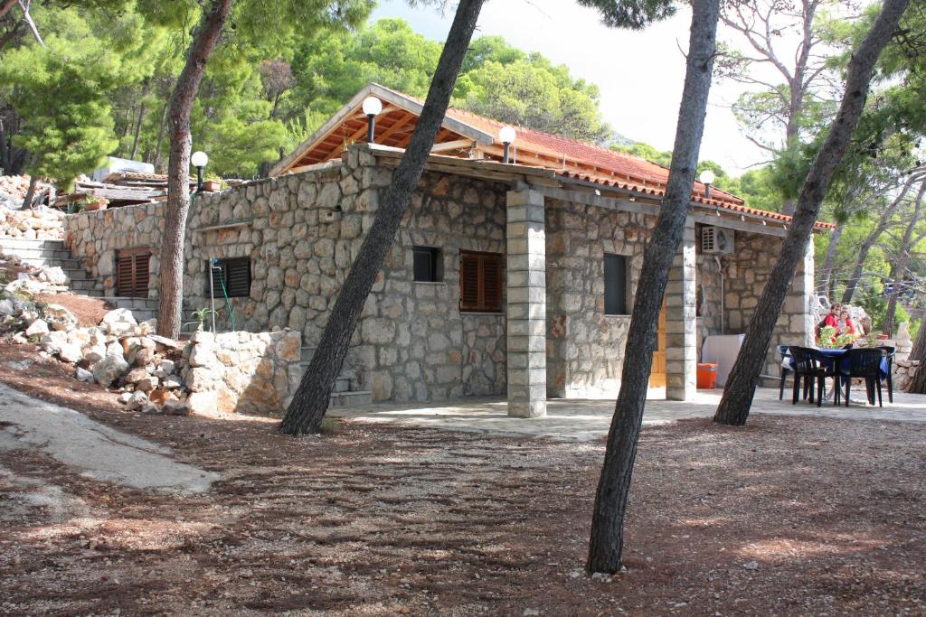 a stone house with trees in front of it at Family friendly seaside apartments Jagodna, Hvar - 3250 in Jelsa