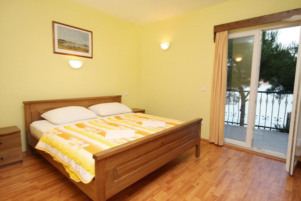 a bedroom with a bed and a large window at Apartments by the sea Rogoznica - 3265 in Rogoznica