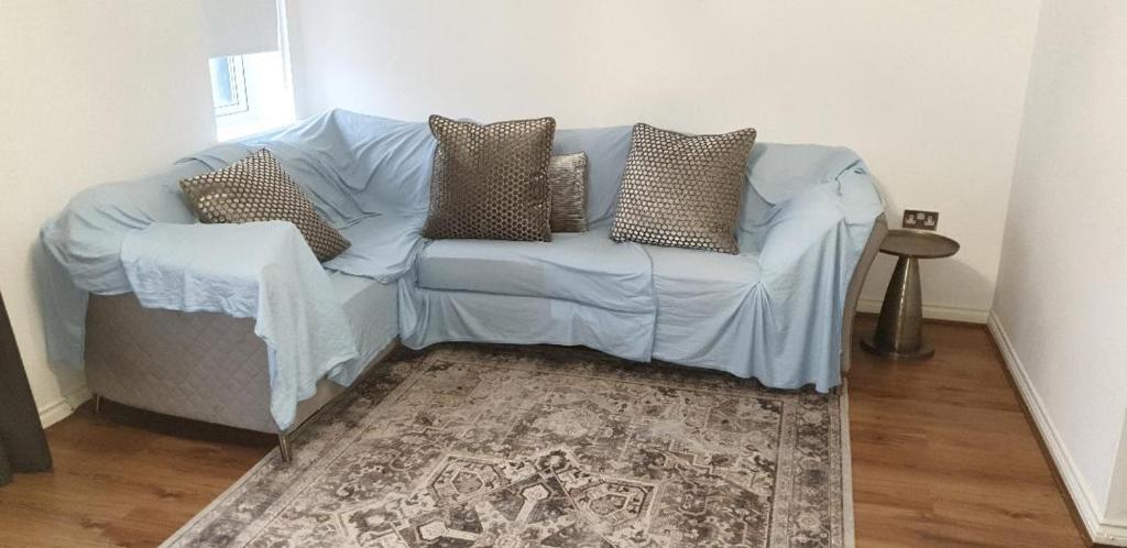 a blue couch in a living room with a rug at Lovely 2-bedroom, 1 bathroom home, sleeps 4 in London