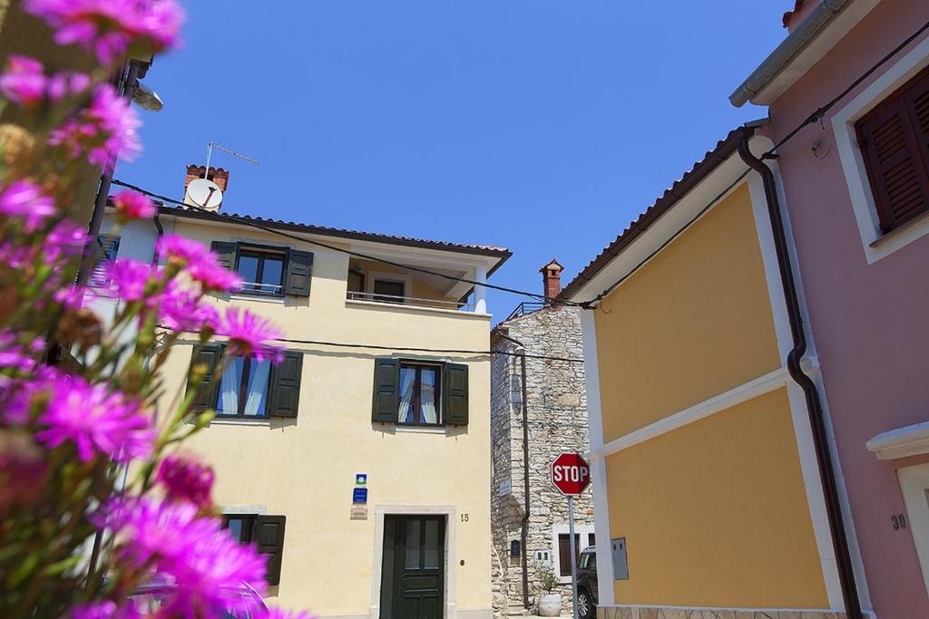 un edificio con una señal de stop y flores rosas en Seaside holiday house Novigrad - 3365, en Novigrad Istria