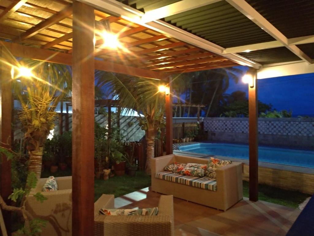 un patio con piscina y pérgola en Pousada Espaco Luz do Sol Beira-Mar en João Pessoa