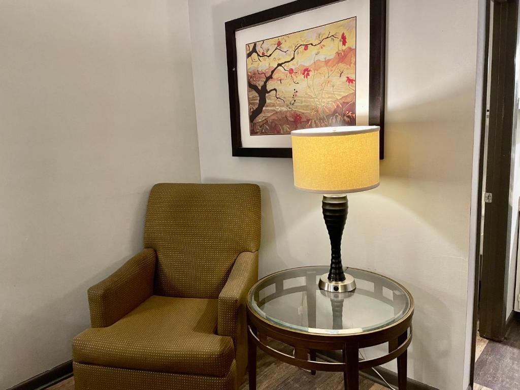 a chair and a lamp on a glass table next to a glass table at Alpine Village Inn in Helen