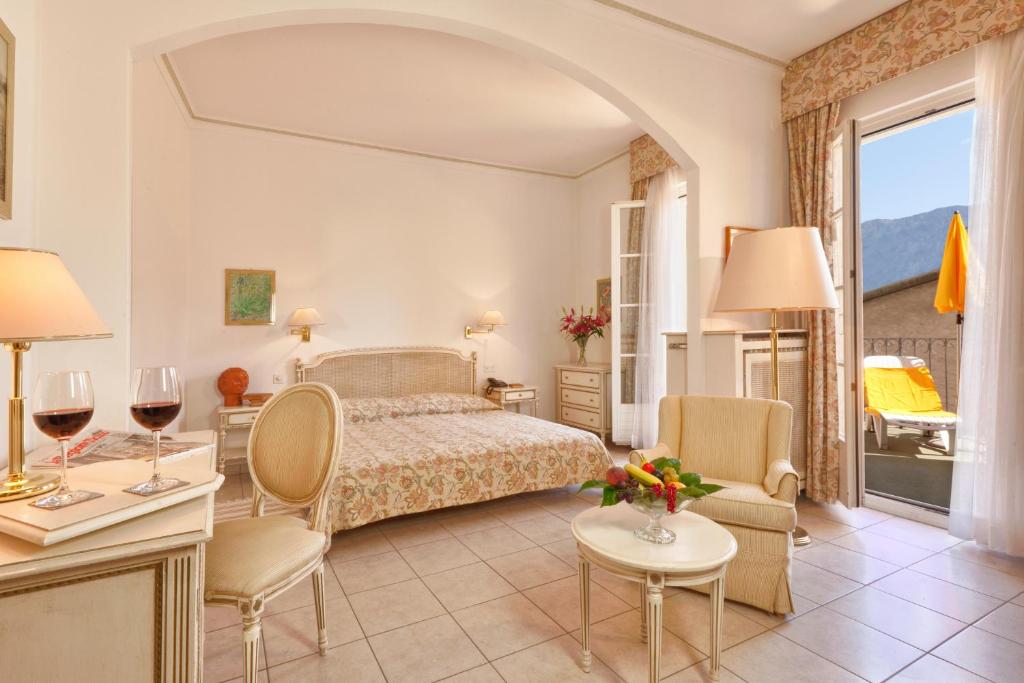 a hotel room with a bed and a table and chairs at Hotel Tamaro in Ascona