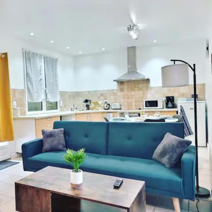 un salon avec un canapé bleu et une table dans l'établissement CHATENAY 4 · Cozy Studio with car park and terrace, à Châtenay-Malabry