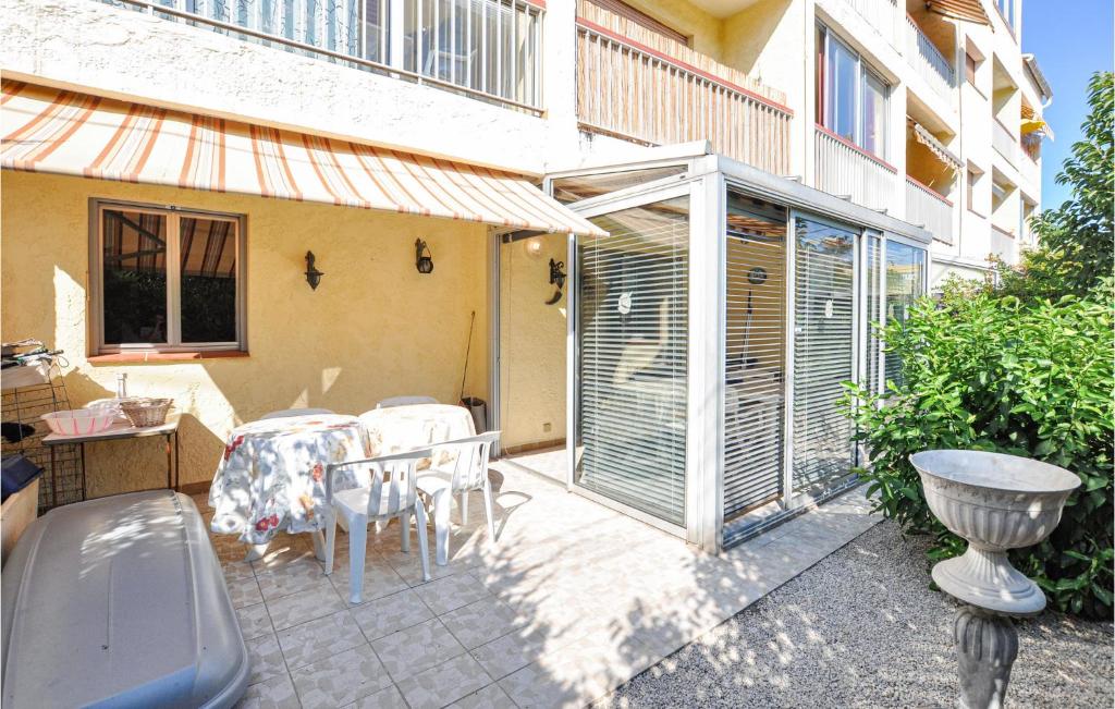 a patio with a table and chairs in front of a building at Nice Apartment In Six-Fours-Les-Plages in Six-Fours-les-Plages