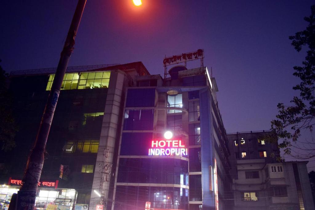 un cartello di innovazione dell'hotel di notte di fronte a un edificio di Hotel Indropuri International a Dhaka
