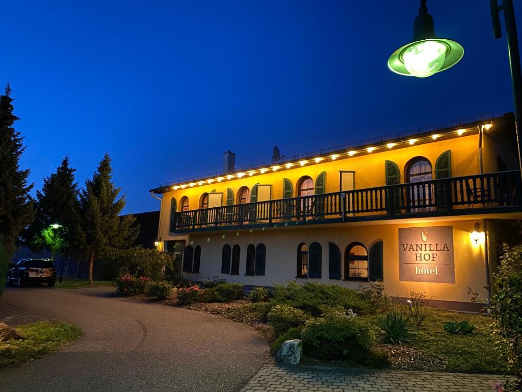 a lit up building with a street light at Vanilla Hof in Naumburg