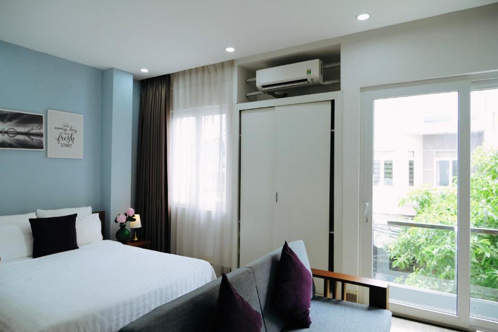 a bedroom with a bed and a sliding glass door at Sunny House in Da Nang