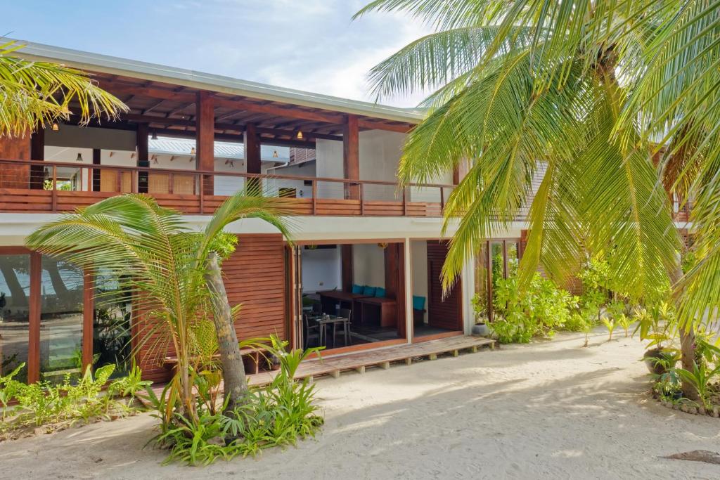 a house on the beach with palm trees at Aveyla Manta Village in Dharavandhoo