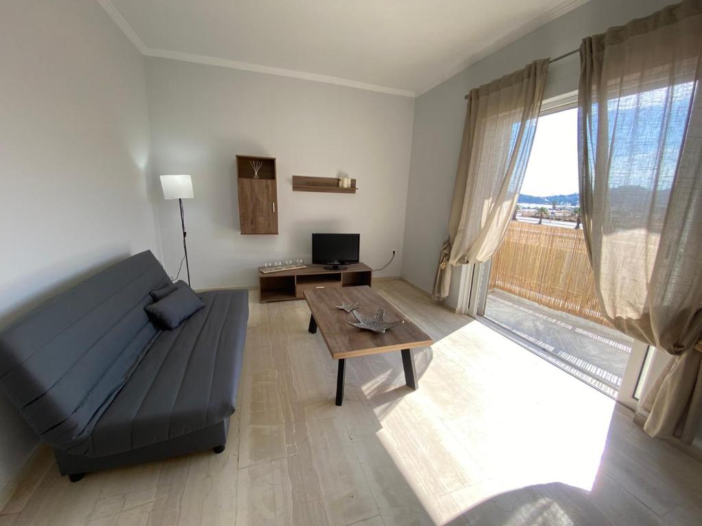 ein Wohnzimmer mit einem Sofa und einem Tisch in der Unterkunft Christy's House Anavissos / Ανάβυσσος in Anavyssos
