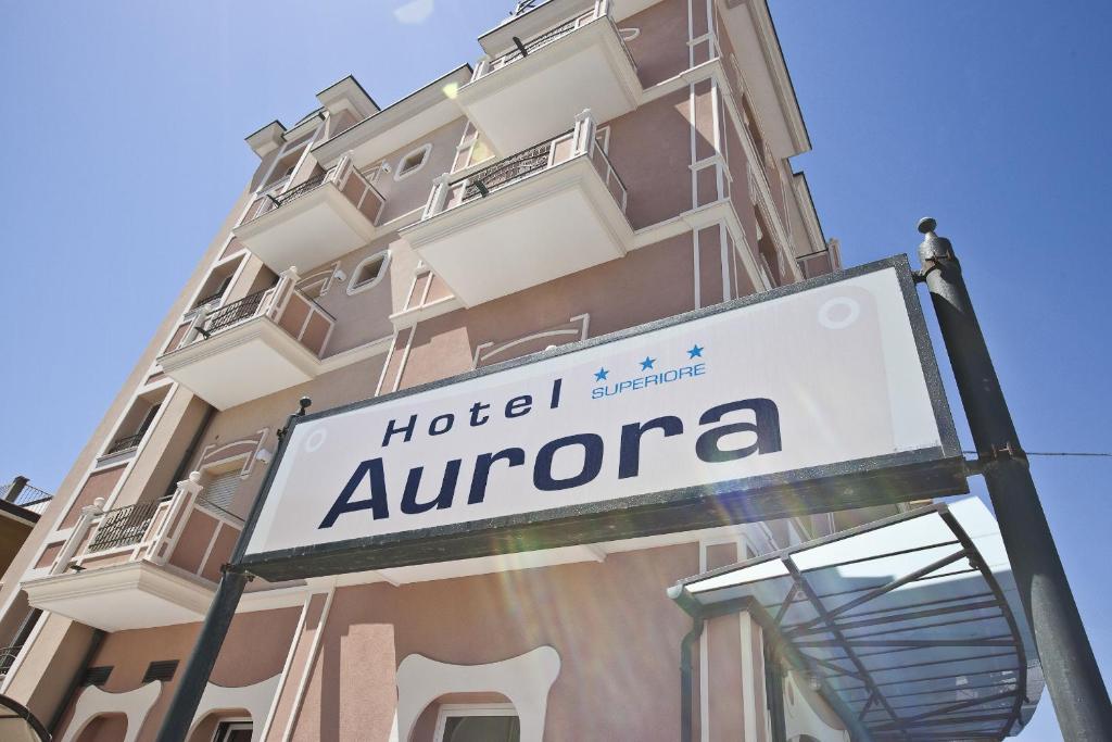 un panneau hotelaquin devant un bâtiment dans l'établissement Hotel Aurora, à Rimini