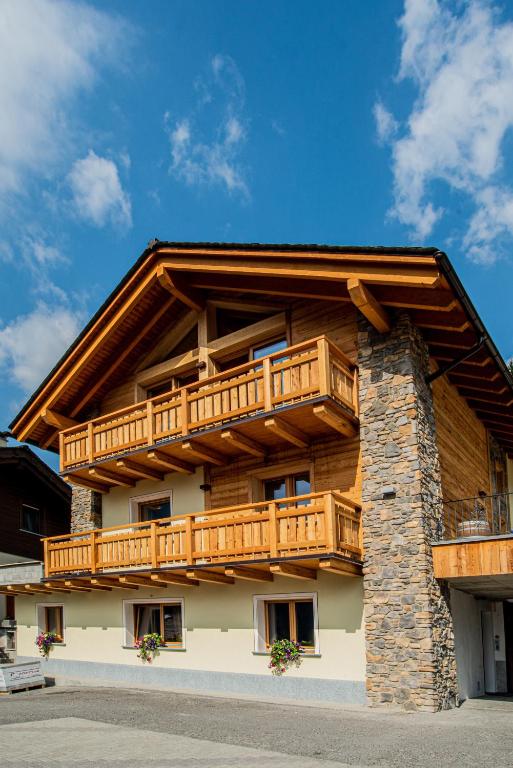 budynek z drewnianymi balkonami na boku w obiekcie Pradella Apartments w mieście Valdidentro