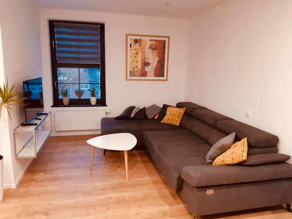 sala de estar con sofá marrón y mesa en City Park Loft, en Münchberg