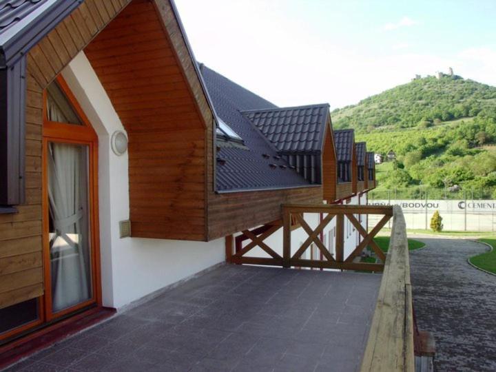a house with a deck with a porch and a mountain at Penzión Réva in Turna nad Bodvou