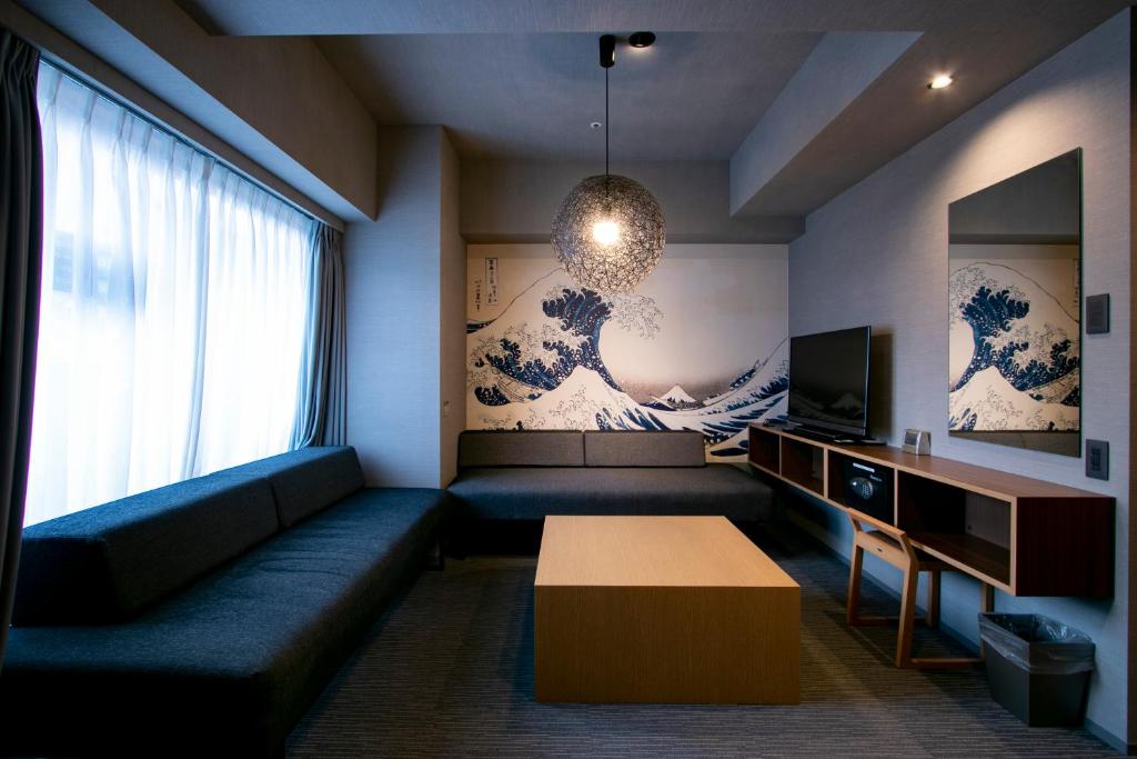 a living room with a couch and a tv and a table at Minn Ueno in Tokyo