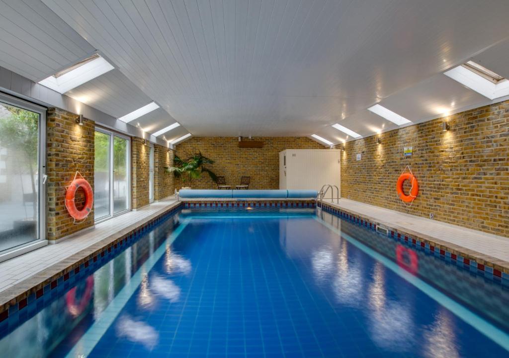 an indoor swimming pool with blue water at La Villa in Rottingdean