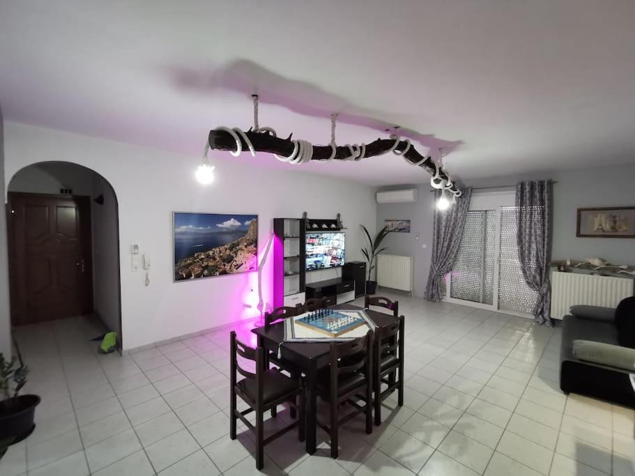 a living room with a table and chairs and purple lights at Elli's House in Keramotí