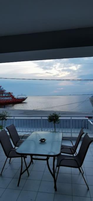 a table and chairs on a balcony with a view of the ocean at Elli's House in Keramoti