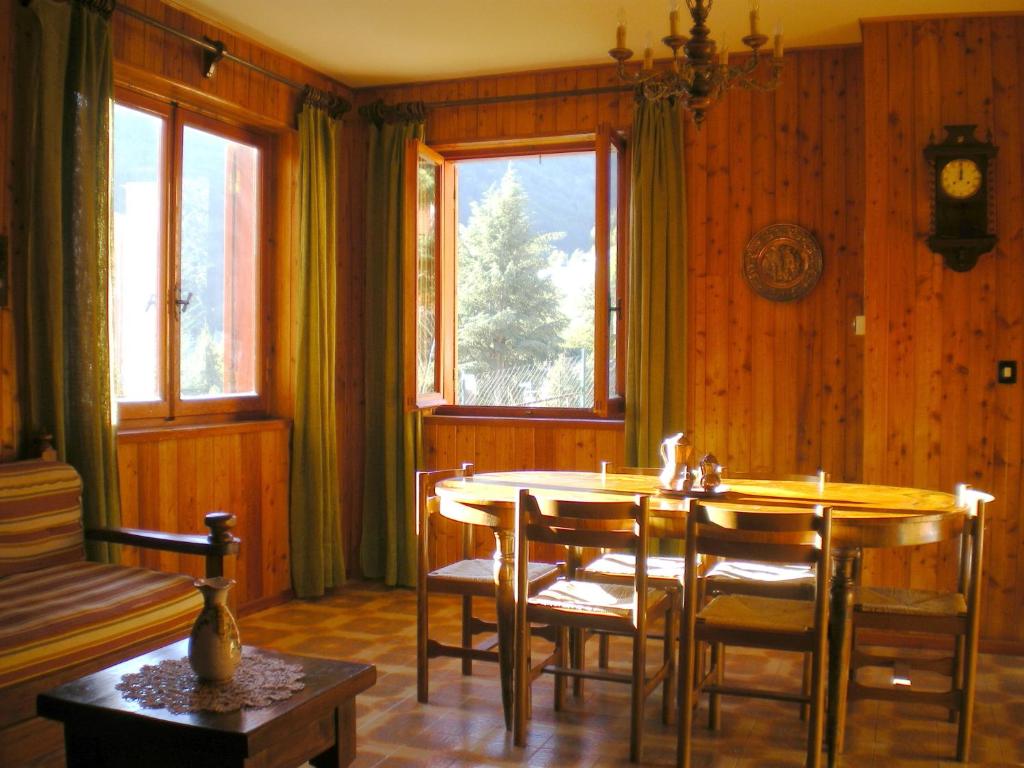 a dining room with a table and chairs and windows at Residence I Comignoli in Scanno