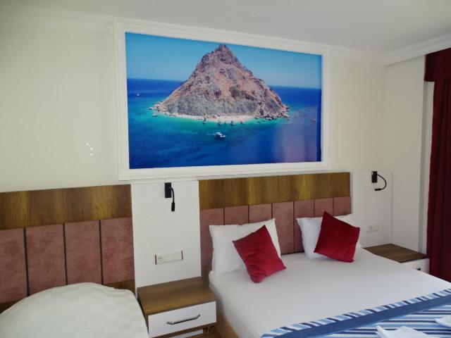 1 dormitorio con 2 camas y una foto de una montaña en Arikanda River Garden Hotel, en Adrasan