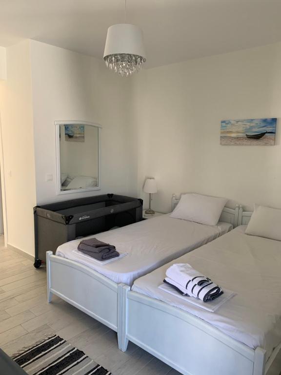 um quarto com 2 camas, uma cómoda e um espelho em Teresa house em Kalivia Poligirou