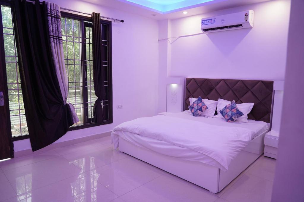 um quarto com uma cama branca e uma janela em Own Stay em Nova Deli